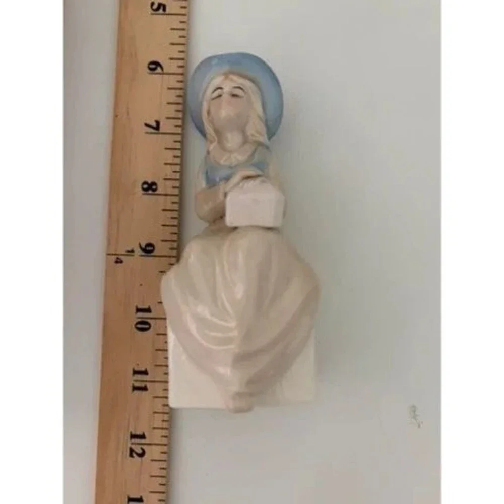 vtg. porcelain figurine of a seated girl wearing a blue hat